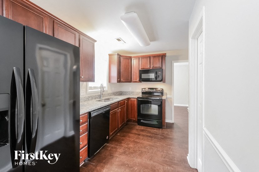 a kitchen with wooden cabinets and stainless steel appliances and black appliances