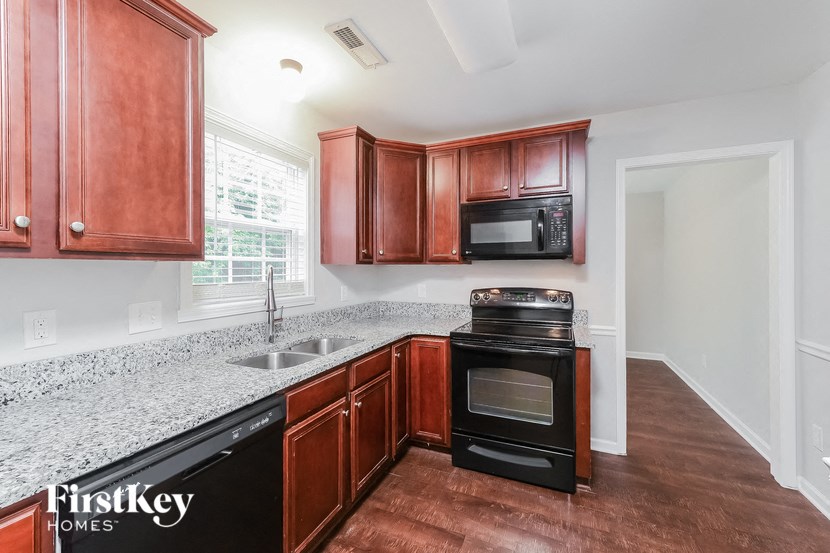 a kitchen with wood cabinets and granite counter tops and black appliances
