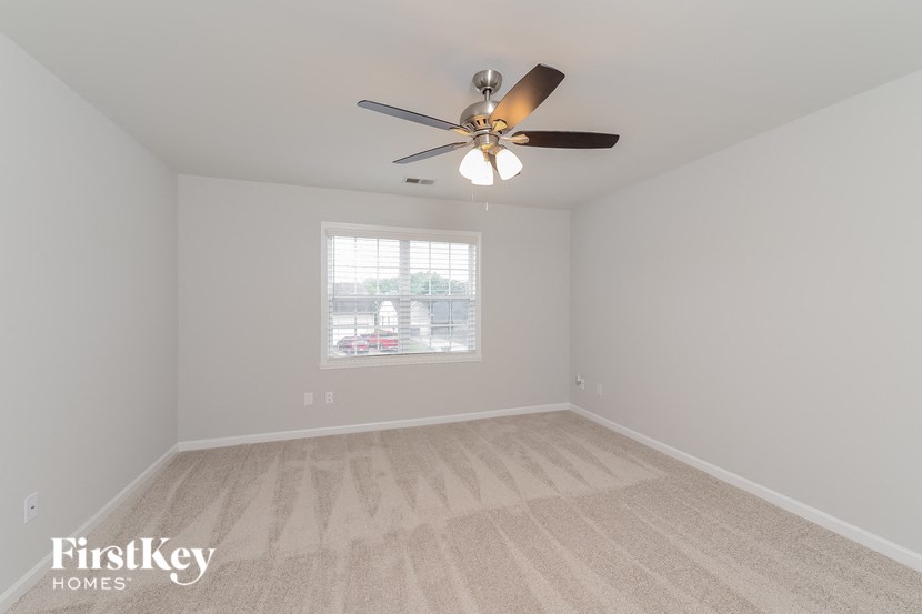 a bedroom with a ceiling fan and a window