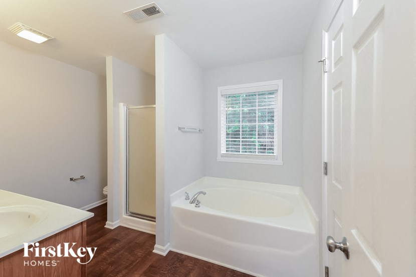 a bathroom with a tub and a shower and a sink