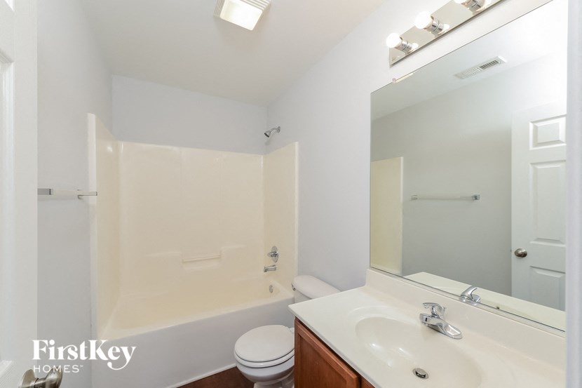 a bathroom with a sink and a mirror and a toilet and a tub