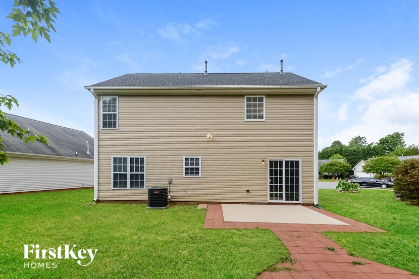 the front of a house with a lawn and a driveway