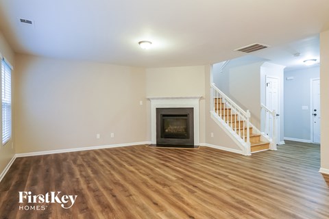 the living room with wood flooring and a fireplace
