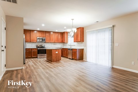 a kitchen and living room with wood flooring and wooden cabinets