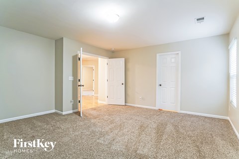 a spacious living room with carpet and white doors