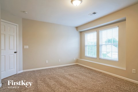 a bedroom with a large window and a white door