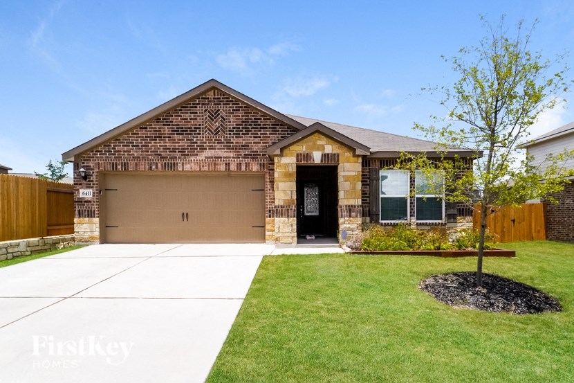 A brick house with a black door and windows.