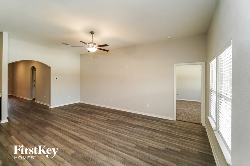 A room with wooden floors and a ceiling fan.