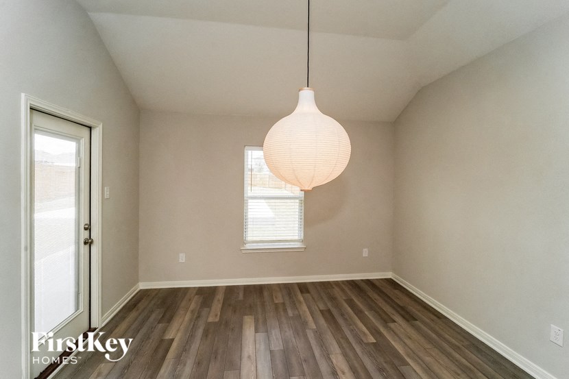 A room with wooden floors and a hanging light fixture.
