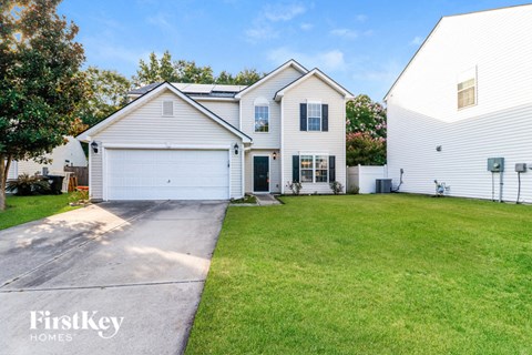 a white house with a driveway and a lawn
