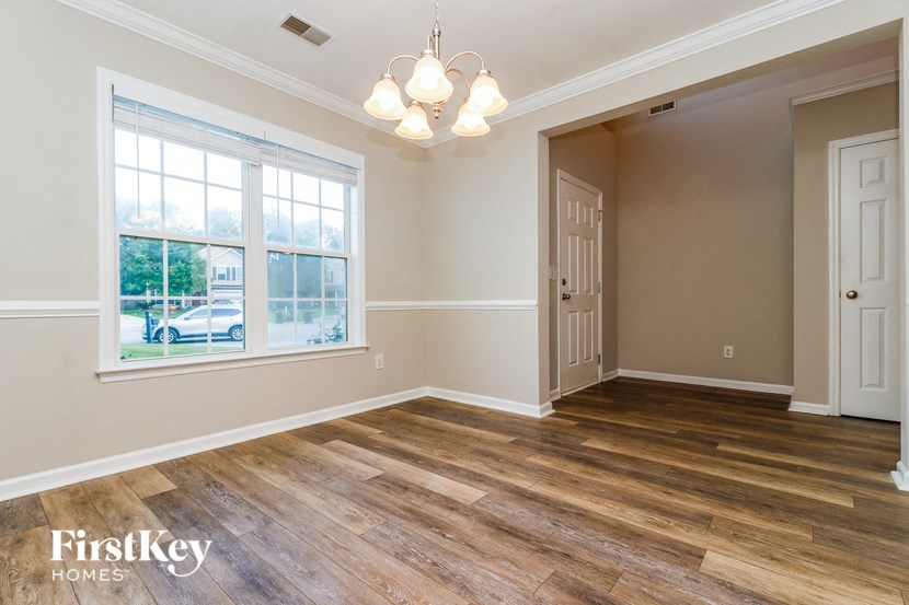 an empty living room with a large window and a door