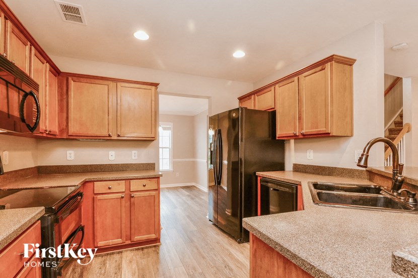 a kitchen with wooden cabinets and a black refrigerator