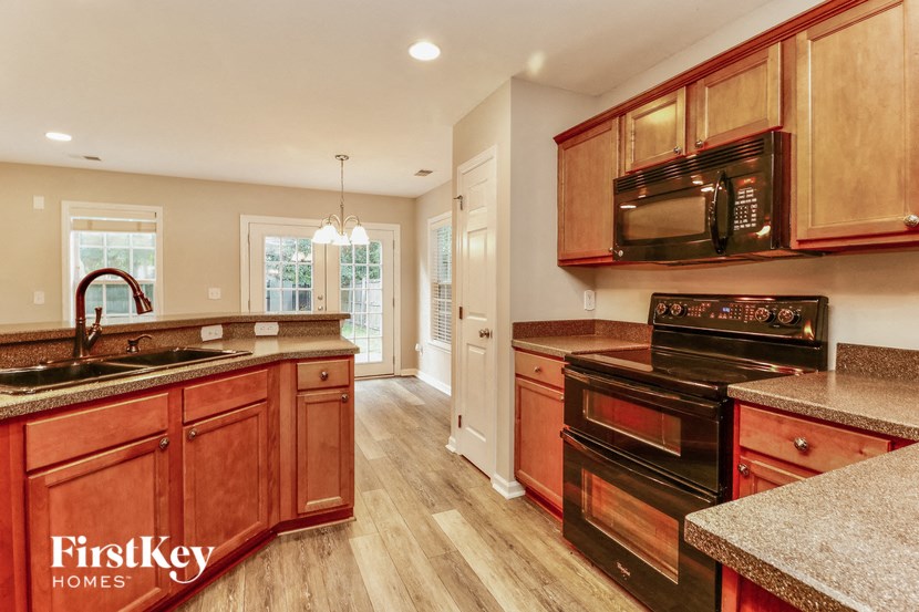 a kitchen with wooden cabinets and black appliances