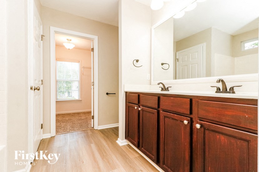 a bathroom with wooden cabinets and a sink and a mirror