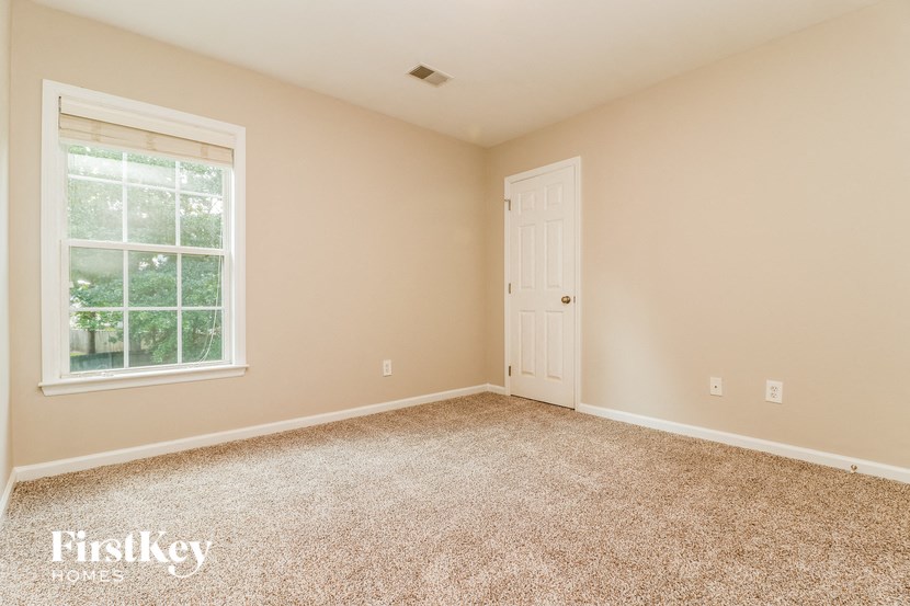 a room with carpet and a window and a door