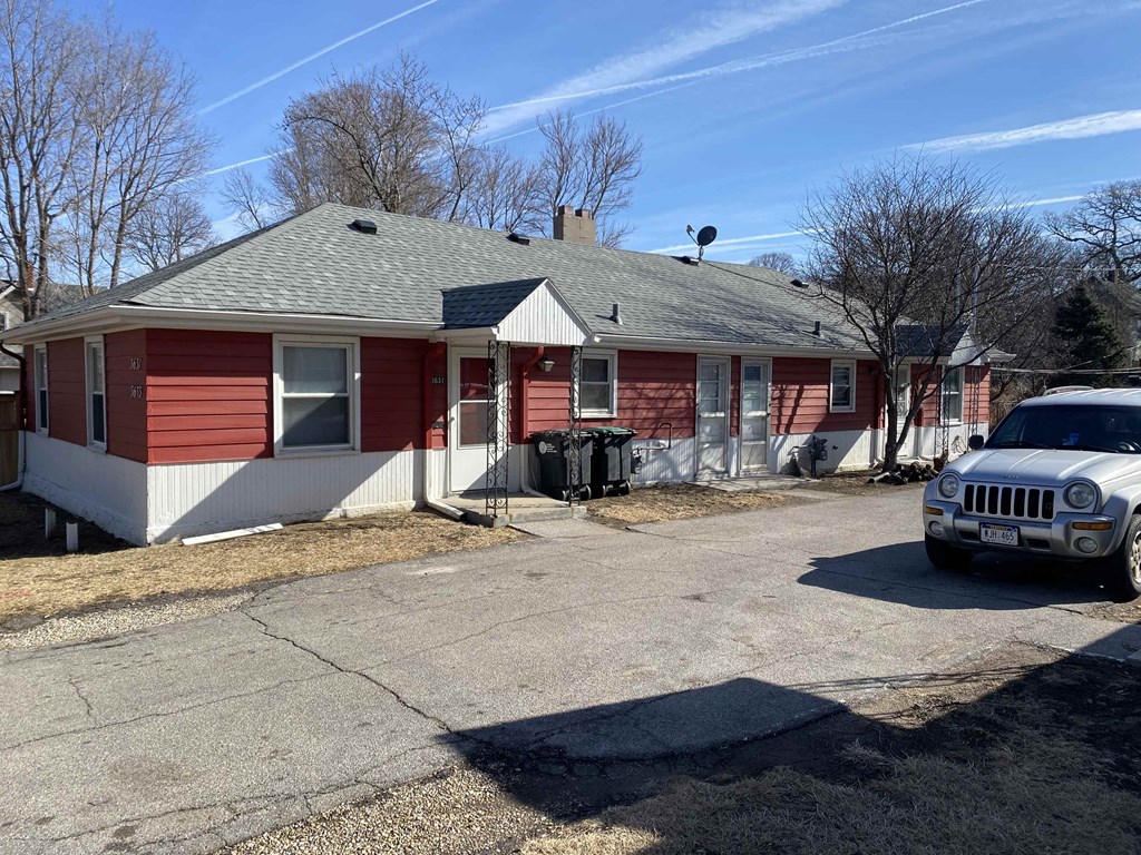 a red and white house with a car parked outside