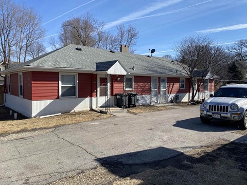 a red and white house with a car parked outside
