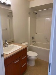 A white toilet sits in a bathroom next to a sink.