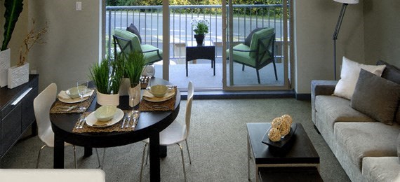 A modern dining room with a glass door leading to a balcony.