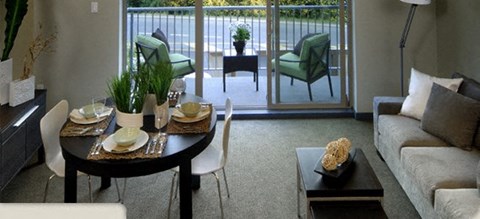 A modern dining room with a glass door leading to a balcony.