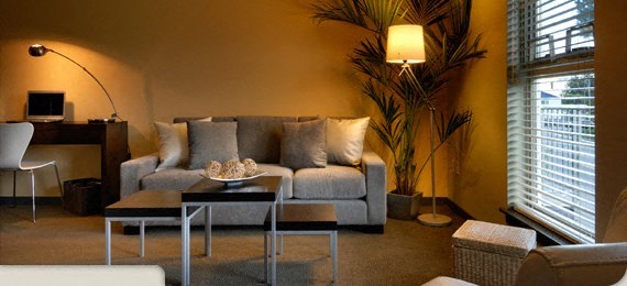 A living room with a grey couch, a coffee table, and a floor lamp.