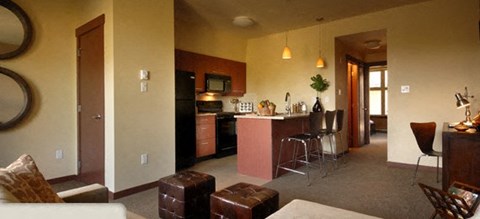 A living room with a couch, chair, and bar area.