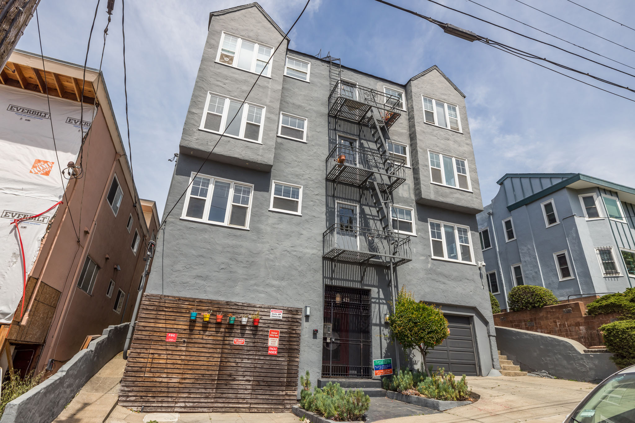A grey building with a fire escape on the front.