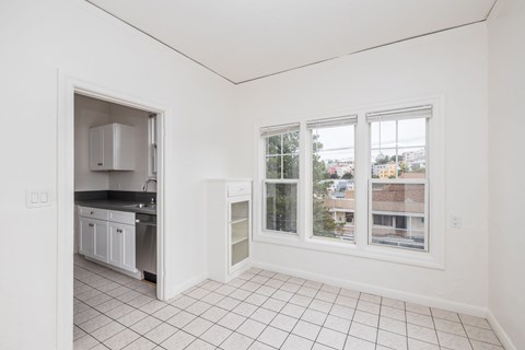 A kitchen with white cabinets and a black countertop is visible from the living room.