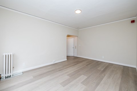 A room with a white wall and a wooden floor.