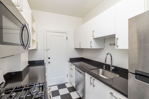 A modern kitchen with a black and white checkered floor.