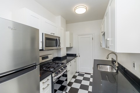 A kitchen with a black and white checkered floor.