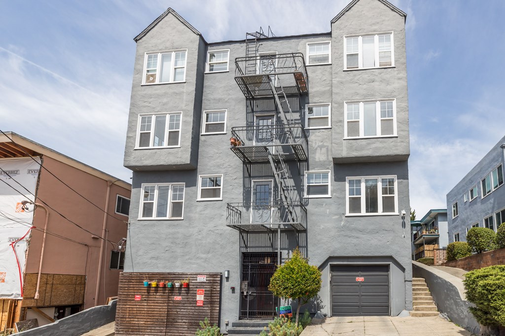 a gray apartment building with a fire escape