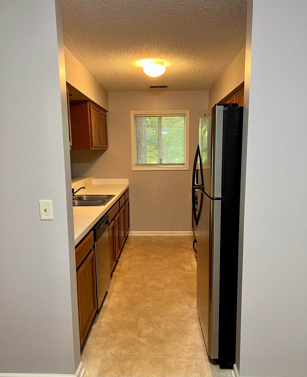 a kitchen with a refrigerator and a sink and a window