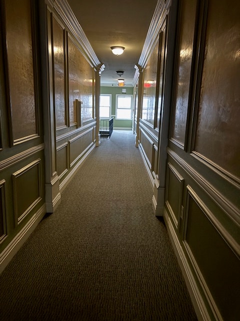 A long hallway with green walls and wood paneling.