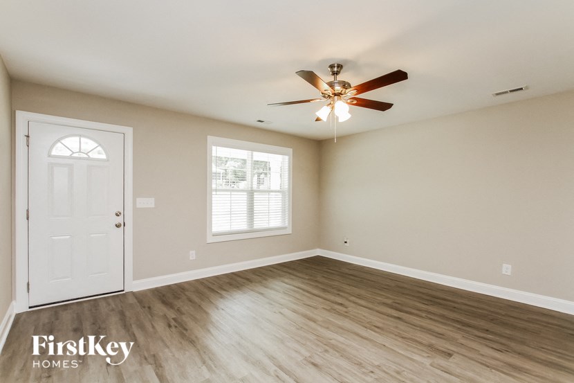 A room with a ceiling fan and a door.