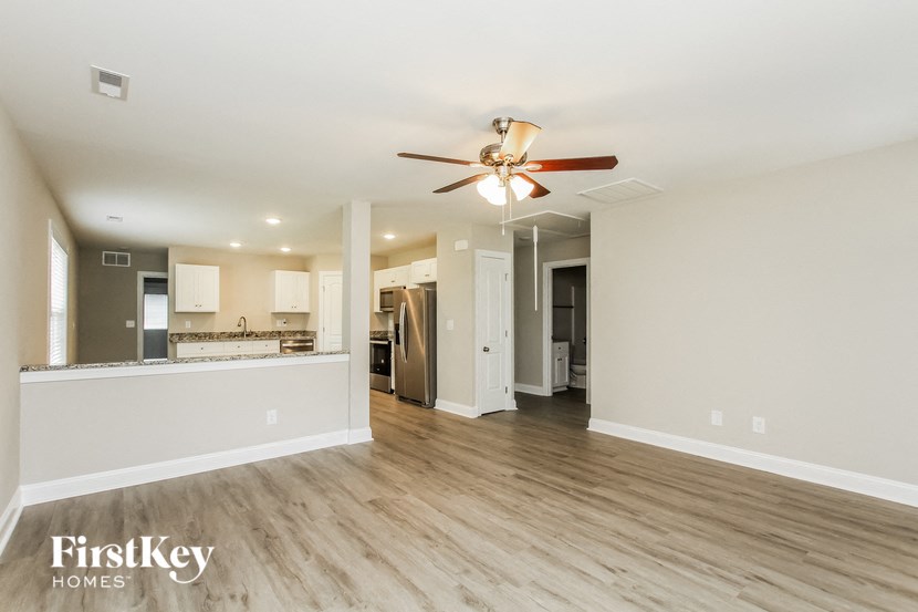A spacious room with a ceiling fan and wooden flooring.
