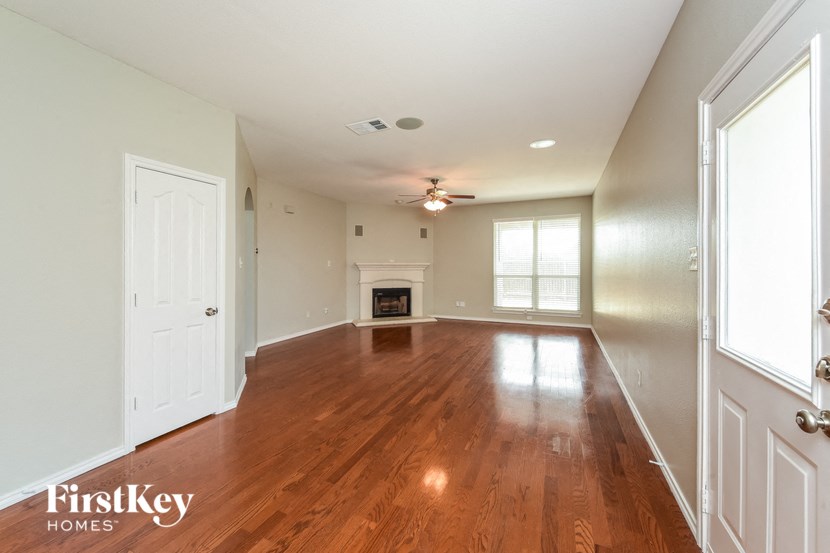 A spacious room with wooden floors and white walls.