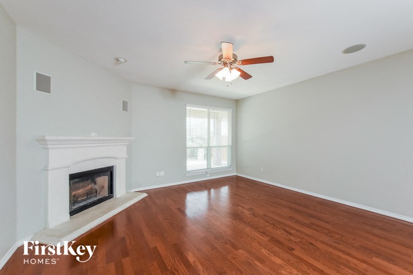 A room with a fireplace and a ceiling fan.