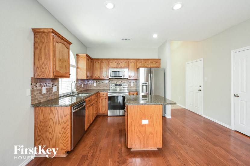 A kitchen with wooden cabinets and a granite countertop.