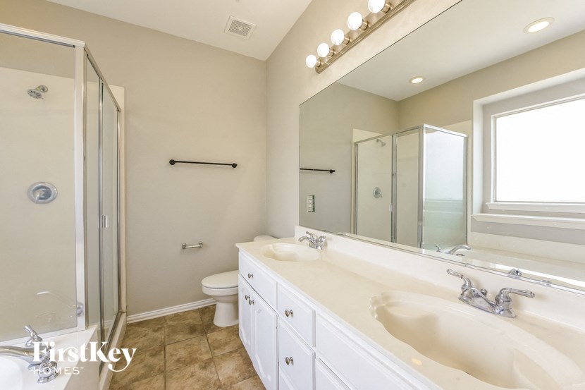 A bathroom with a large mirror and a walk-in shower.