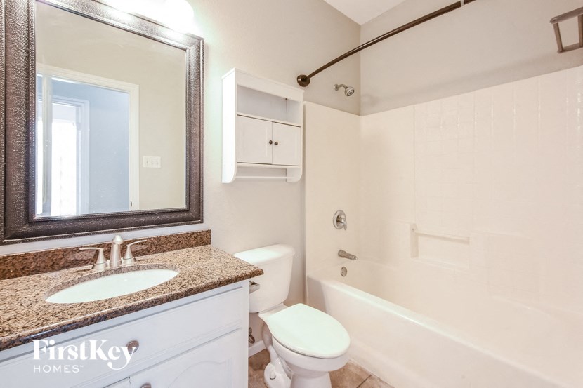 A bathroom with a sink, toilet, and bathtub.