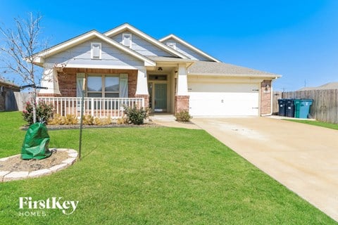 a home with a lawn and a driveway and a porch