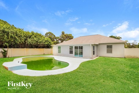 A house with a green pool in the backyard.