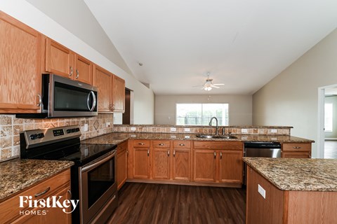 A kitchen with wooden cabinets and a granite countertop.