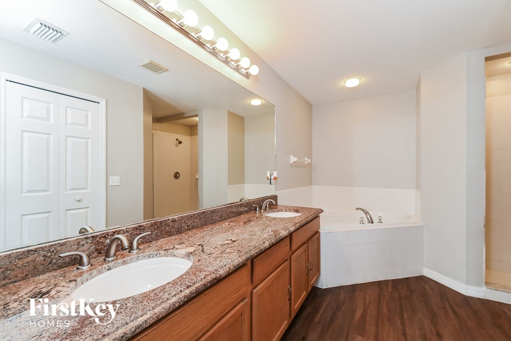 A bathroom with a granite countertop and a large mirror.
