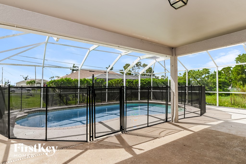 A pool enclosed by a black fence with a FirstKey logo on the bottom left.