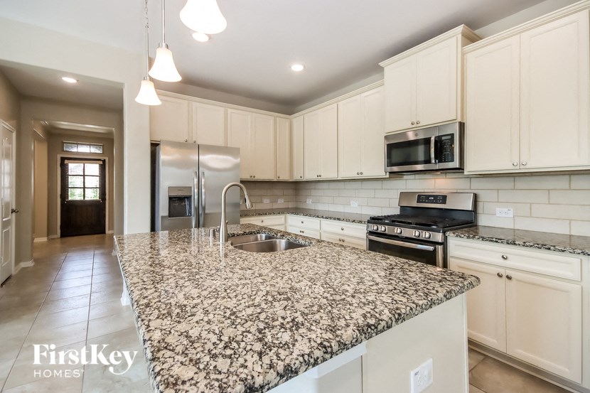 a kitchen with white cabinets and granite counter tops