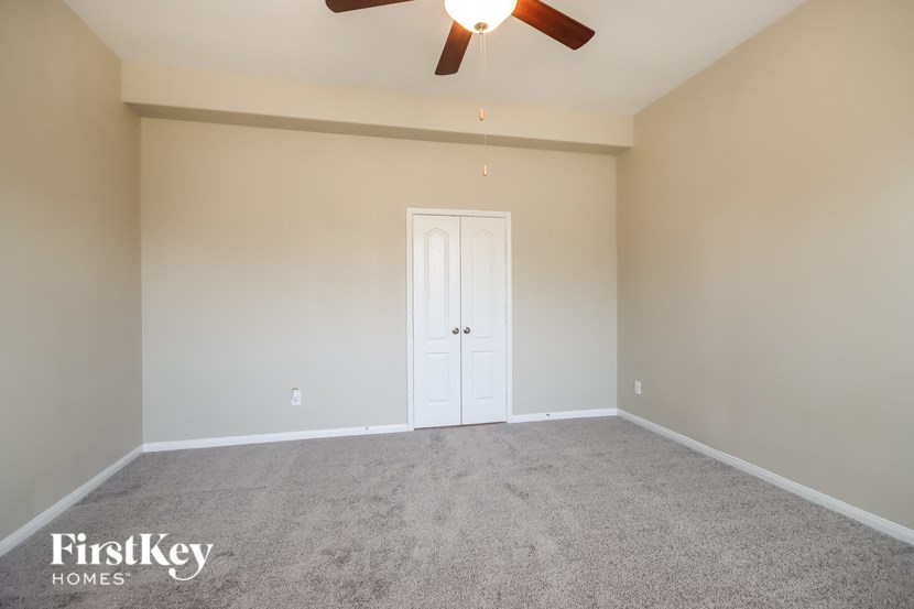 a empty room with a ceiling fan and a white door