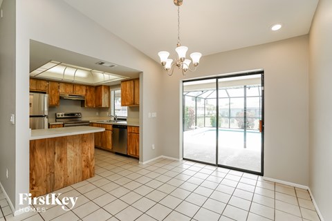A kitchen with wooden cabinets and a tiled floor.
