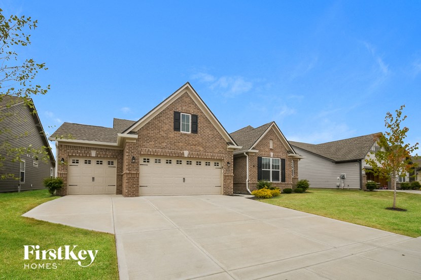 a brick house with two garage doors and a driveway